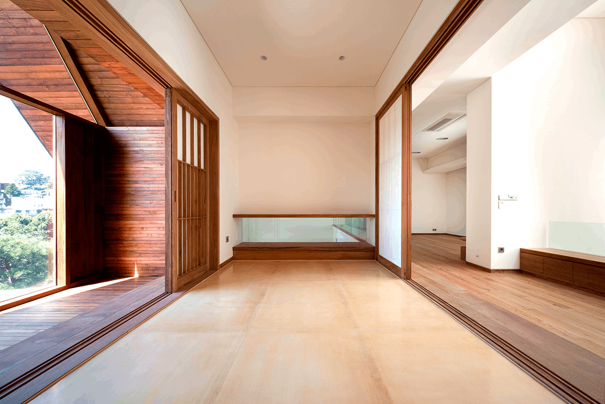 Weitwinkelaufnahme eines Forums, mit Blick nach draußen und vielen Holzelementen, dessen Wände mit der Lehmfarbe I-PAINT gestrichen wurden