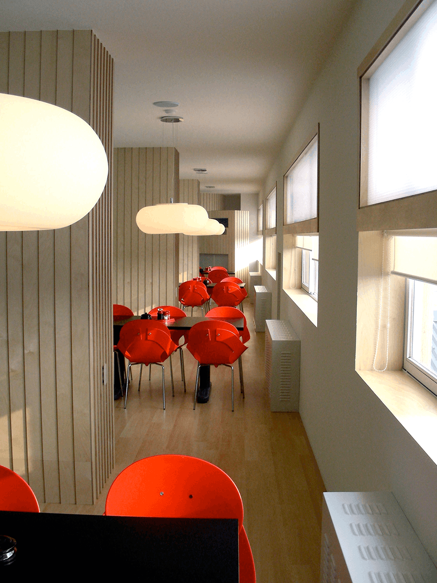 Foto eines Speisesaals mit roten Designstühlen, in einem Hotel  dessen Wände mit der Lehmfarbe I-PAINT gestrichen wurden