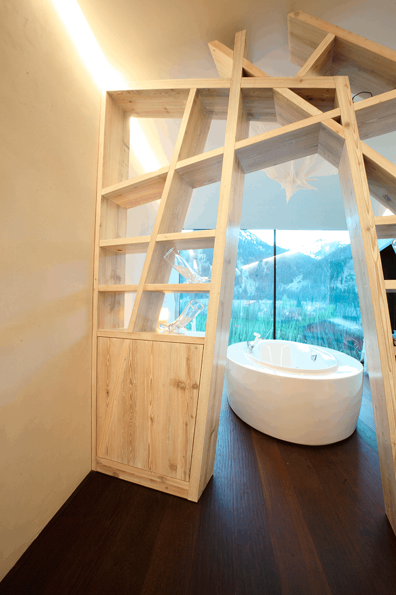 Foto einer Wand die mit der Lehmfarbe I-PAINT gestrichen wurde, sowie einer freistehenden Badewanne auf dunklem Holzboden